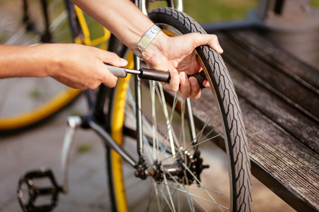 Out-of-frame person inflating a bike tire.